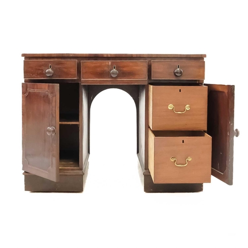 647 - A George III mahogany kneehole desk. With three short drawers over two cupboards on plinth bases, he... 