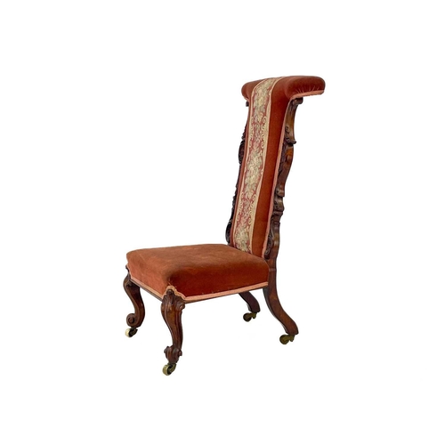 652 - A Victorian rosewood framed prie dieu chair. With carved side pieces, on cabriole front legs and bra... 