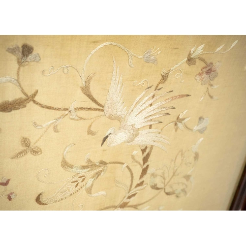 664 - An Edwardian walnut wide fire screen. The embroidered panel with two exotic birds, and foliage, heig... 