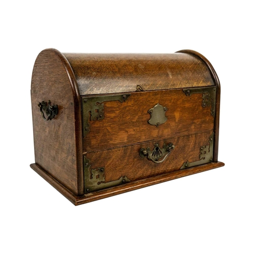 71 - An Edwardian oak dome top smokers compendium. With plated mounts, the drawer opens to reveal two com... 