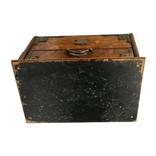 71 - An Edwardian oak dome top smokers compendium. With plated mounts, the drawer opens to reveal two com... 