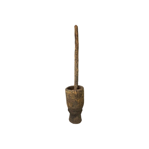 100 - A Zimbabwean pestle and mortar or grain pounder. Circa 1950, the mortar of waisted form, with a cent... 