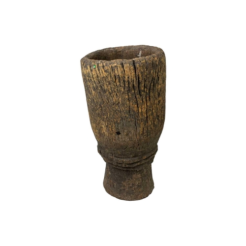 100 - A Zimbabwean pestle and mortar or grain pounder. Circa 1950, the mortar of waisted form, with a cent... 