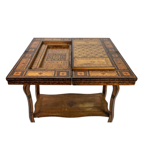 103 - A Syrian inlaid parquetry games table, 19th century. The swivel fold over top with a folding baize l... 