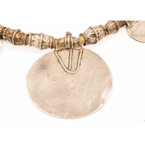 104 - An Omani silver amulet with four coins. With rows of inscription, full length 39cm, diameter 7.5cm.