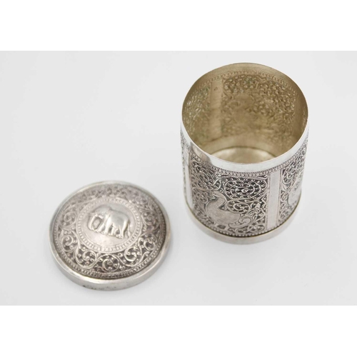 112 - An Indian silver cannister, early 20th century. The cover repousse decorated with an elphant within ... 