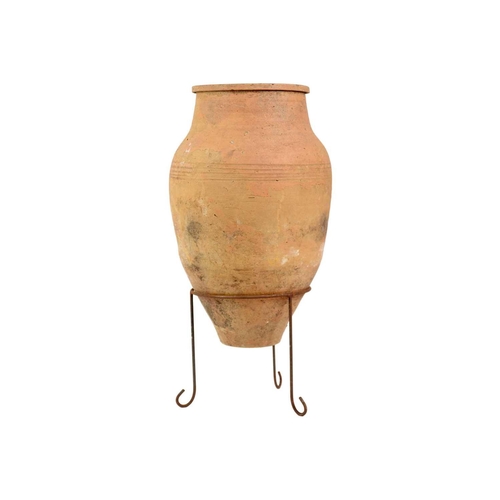 118 - A terracotta olive jar on metal stand. Height 79cm, width 35cm.