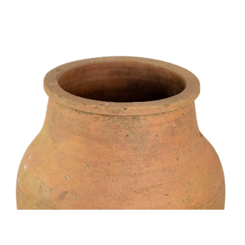 118 - A terracotta olive jar on metal stand. Height 79cm, width 35cm.