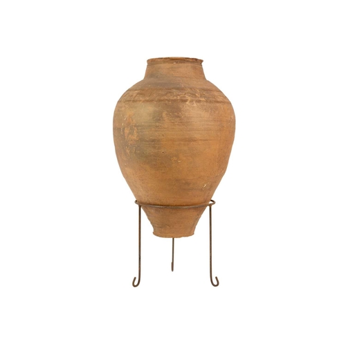 119 - A terracotta olive jar on metal stand. Height 81cm, width 39cm.