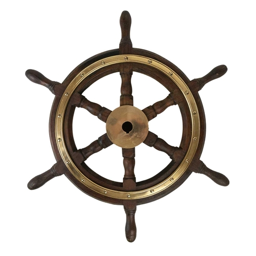 14 - A six spoke teak and brass bound yacht wheel by Simpson Lawrence. Diameter 53cm.