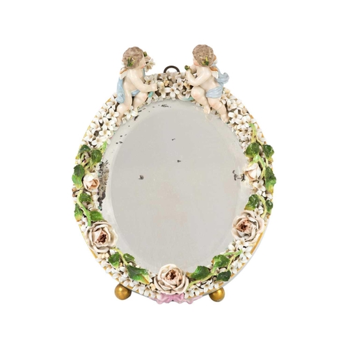 168 - A German porcelain dressing table mirror, early 20th century. The floral encrusted frame surmounted ... 