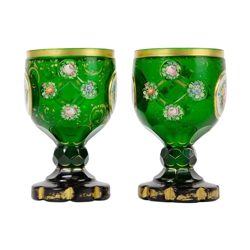 181 - A pair of Bohemian green glass goblets, 19th century. Each with floral painted panels and gilt decor... 