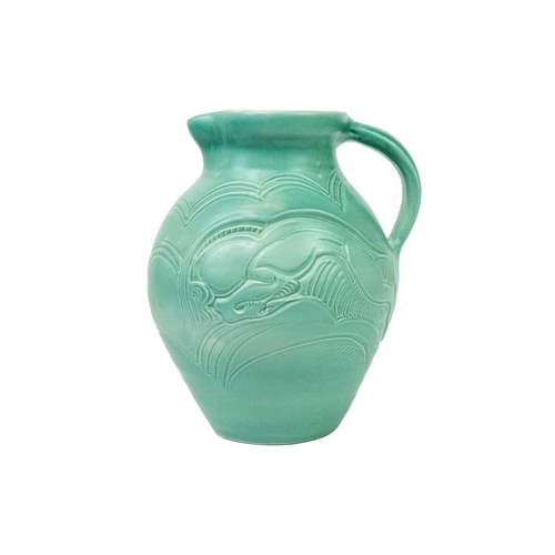 190 - A Susie Cooper pottery jug. In turquoise glaze and decorated with incised leaping beasts, signed to ... 