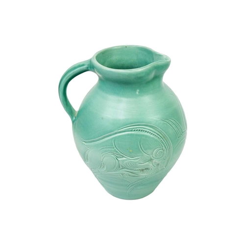 190 - A Susie Cooper pottery jug. In turquoise glaze and decorated with incised leaping beasts, signed to ... 