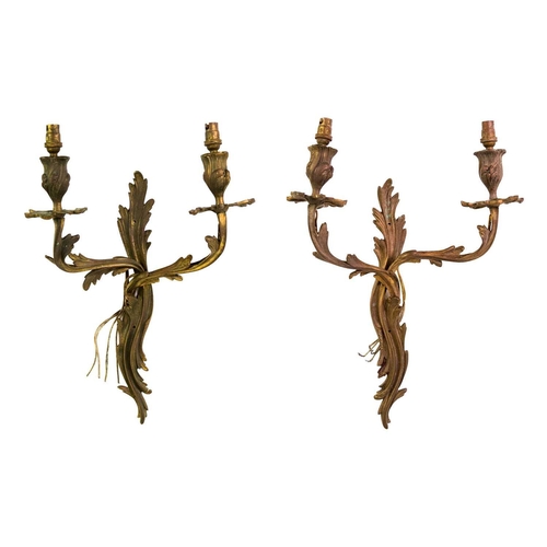 248 - A pair of gilt brass rococo twin branch wall sconces. Circa 1900, each cast and chased with scrollin... 