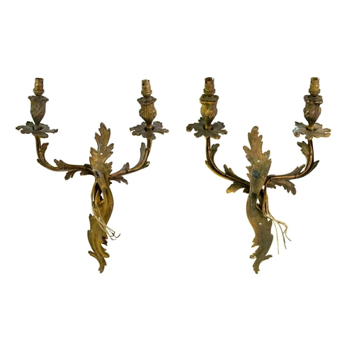 248 - A pair of gilt brass rococo twin branch wall sconces. Circa 1900, each cast and chased with scrollin... 