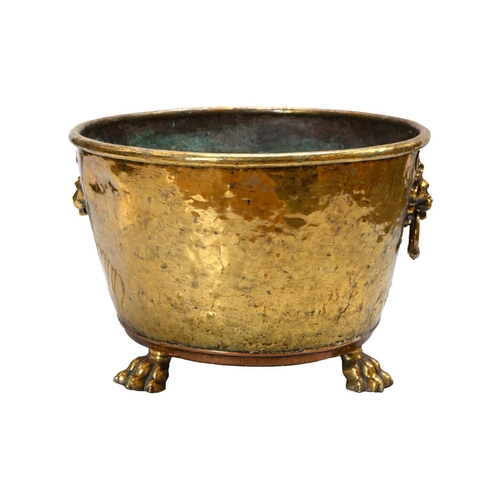 26 - A Victorian brass and copper log bin. With lion mask handles and raised on paw feet, height 33cm, di... 