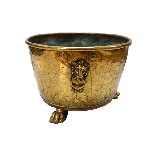 26 - A Victorian brass and copper log bin. With lion mask handles and raised on paw feet, height 33cm, di... 