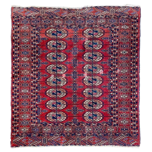 264 - A Tekke rug, circa 1920's. The madder field with two rows of eight large guls, within a sunburst gul... 