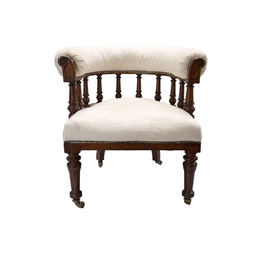 289 - A Victorian upholstered oak frame tub chair. The bow back above turned spindles on ceramic castor wh... 