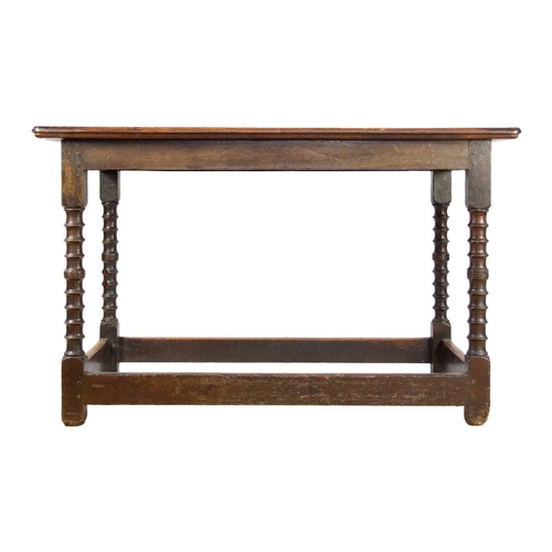 310 - An 18th/19th century oak side table. The rectangular top on ring turned supports joined by stretcher... 