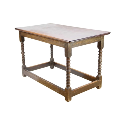 310 - An 18th/19th century oak side table. The rectangular top on ring turned supports joined by stretcher... 