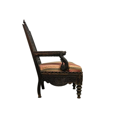 311 - A Burmese carved wood open armchair, 19th century. With two figural finials above a profusely carved... 