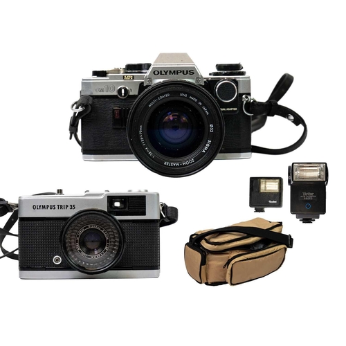 32 - An Olympus OM10 SLR camera. Fitted with a Sigma Zoom Master 35-70mm lens and other accessories toget... 