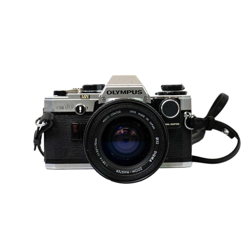 32 - An Olympus OM10 SLR camera. Fitted with a Sigma Zoom Master 35-70mm lens and other accessories toget... 