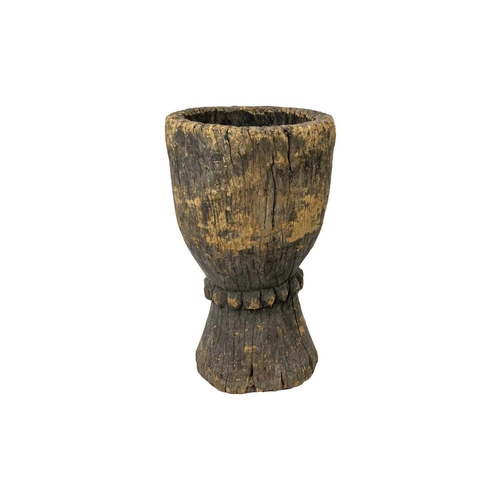 92 - A Zimbabwean pestle and mortar or grain pounder. Circa 1930, of waisted form, with a carved central ... 