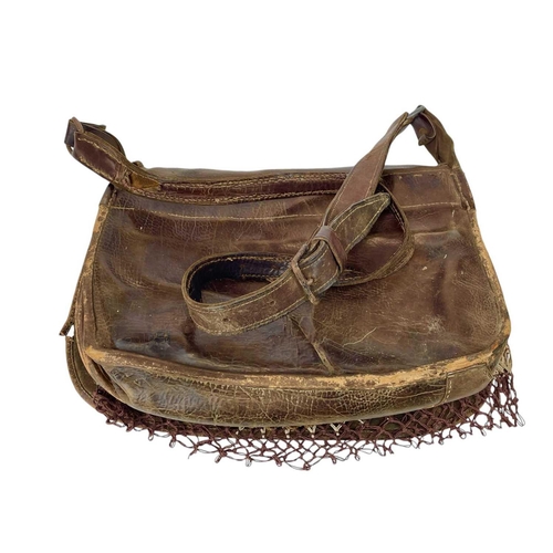 11 - A leather poacher's or hunter's bag. Circa 1920, with cartridge compartments and a net bag, with str... 