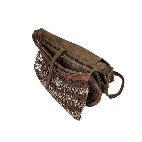 11 - A leather poacher's or hunter's bag. Circa 1920, with cartridge compartments and a net bag, with str... 