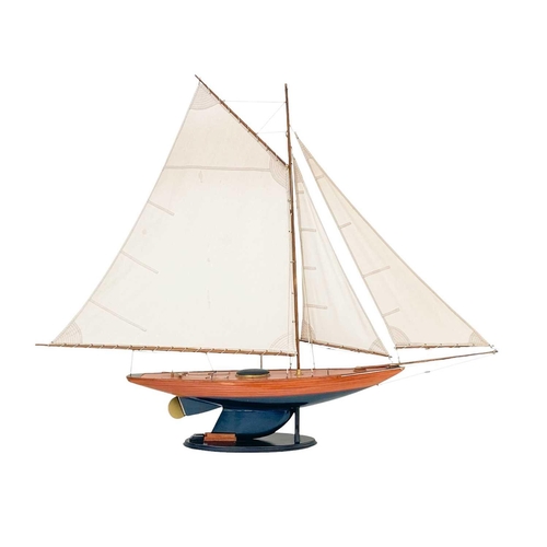 122 - A model of a racing yacht. With a simulated planked deck, painted hull, on a stand, height 123cm.