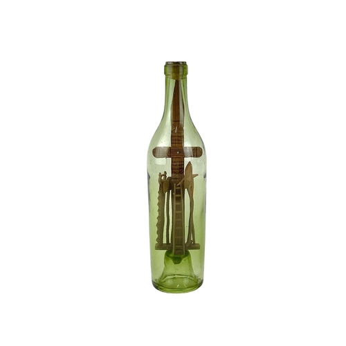 159 - A folk art 'God in a Bottle' The green glass bottle circa 1900, containing a pitch pine cross with a... 