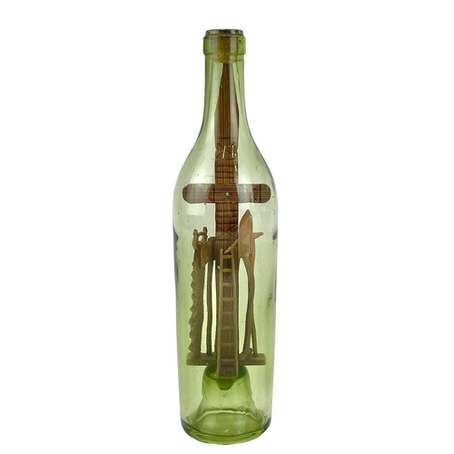 159 - A folk art 'God in a Bottle' The green glass bottle circa 1900, containing a pitch pine cross with a... 