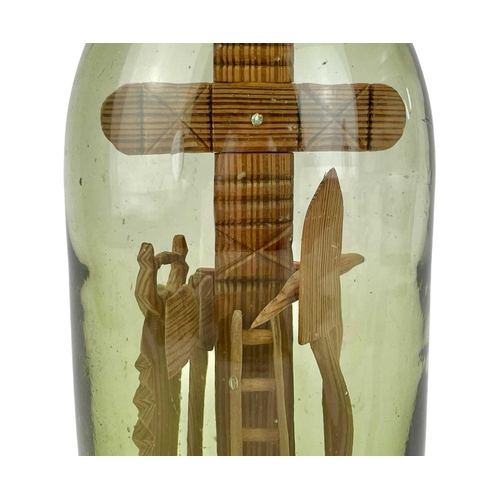 159 - A folk art 'God in a Bottle' The green glass bottle circa 1900, containing a pitch pine cross with a... 