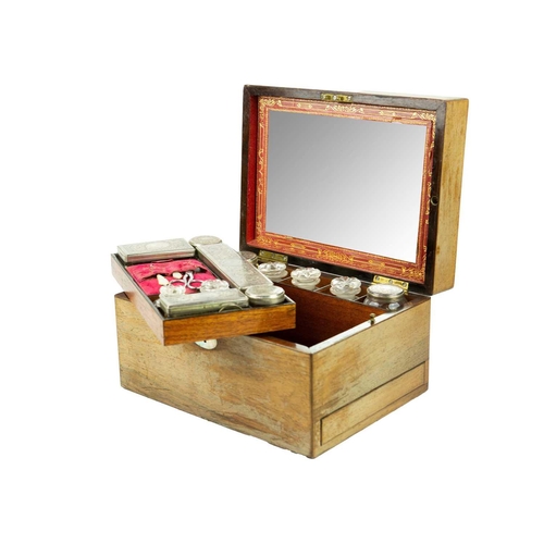 168 - A Victorian rosewood fitted vanity box. The lid with a mirror, the tray with glass jars, some with p... 