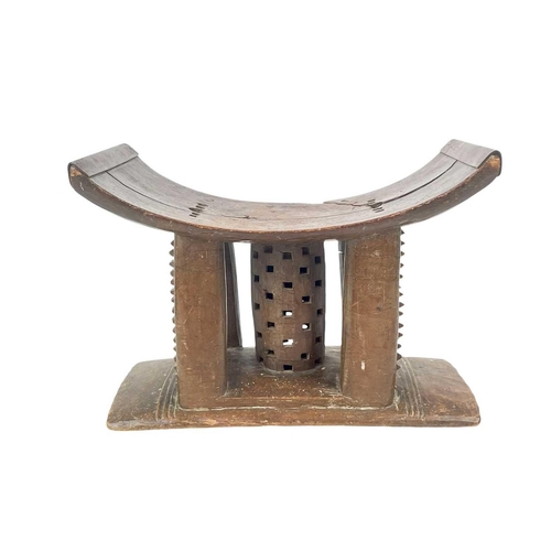 188 - An Ashanti stool. Probably 19th century, of typical form, height 29cm, the top with later brass stre... 