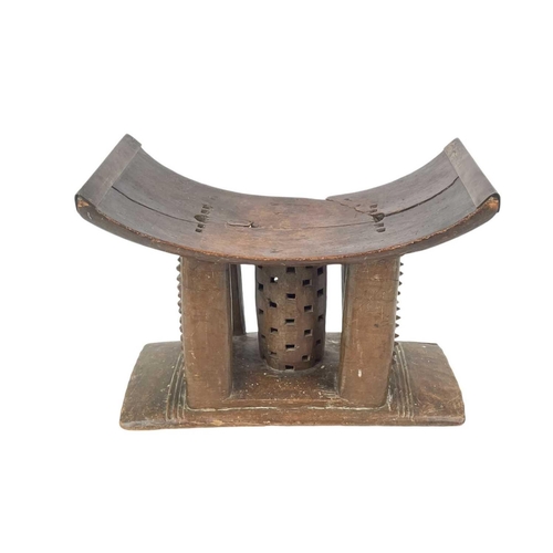 188 - An Ashanti stool. Probably 19th century, of typical form, height 29cm, the top with later brass stre... 