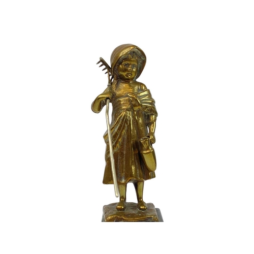 23 - A bronze figure of a farm girl signed E Kuske raised on a square marble base Height 15.5cm together ... 