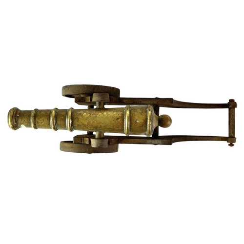 4 - A brass and iron model cannon. Height 21cm length 46cm.