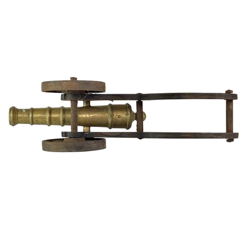 4 - A brass and iron model cannon. Height 21cm length 46cm.