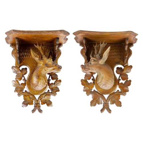 75 - A pair of Black Forest linden wood wall brackets. Late 19th century, each carved with a stag head an... 