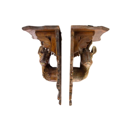 75 - A pair of Black Forest linden wood wall brackets. Late 19th century, each carved with a stag head an... 