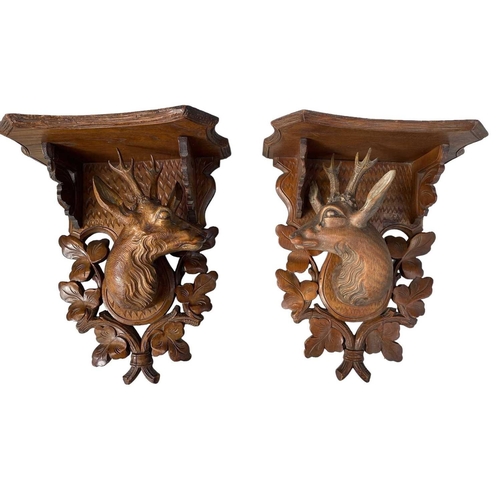 75 - A pair of Black Forest linden wood wall brackets. Late 19th century, each carved with a stag head an... 