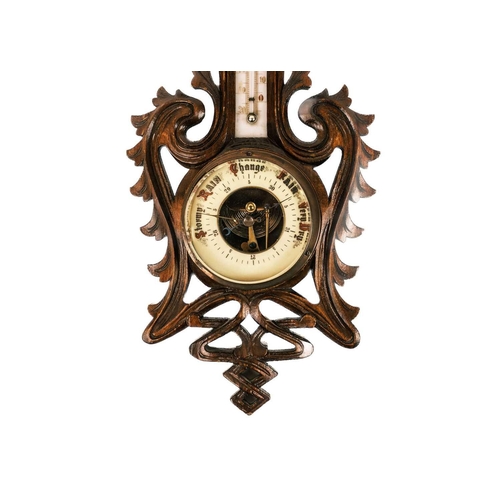 9 - A Black Forest aneroid barometer. In a carved and pierced case, height 48cm, together with a pair of... 