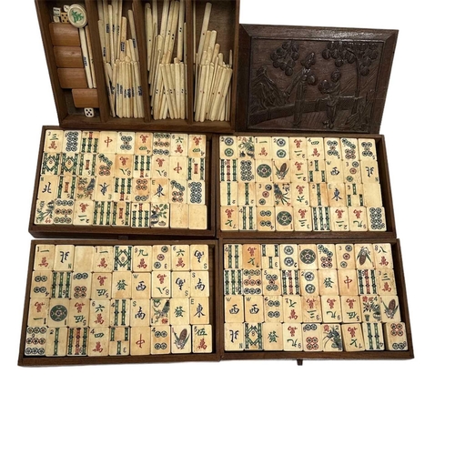 11 - A Chinese Mah-jong set, in a carved wood case, circa 1900. With five drawers enclosing bone and bamb... 