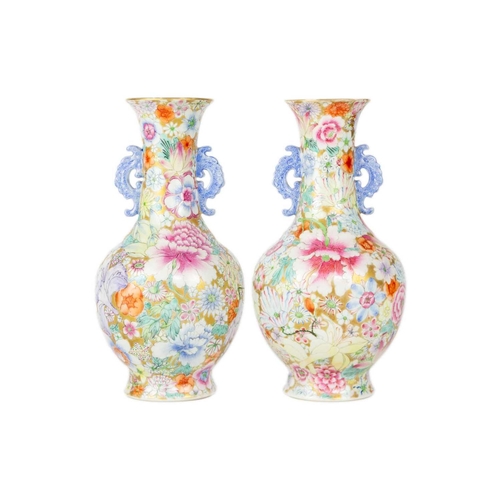 135 - A pair of Chinese millefleur twin handled vases, circa 1900. Profusely decorated with enamelled flow... 