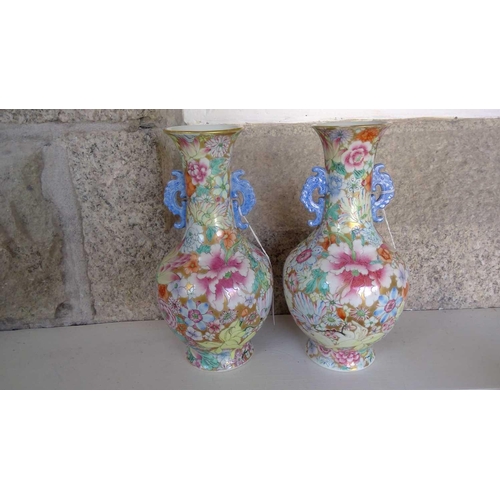 135 - A pair of Chinese millefleur twin handled vases, circa 1900. Profusely decorated with enamelled flow... 