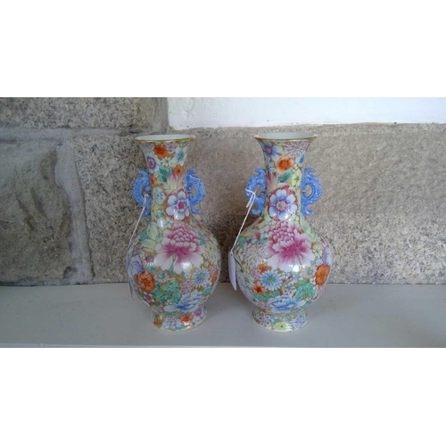 135 - A pair of Chinese millefleur twin handled vases, circa 1900. Profusely decorated with enamelled flow... 